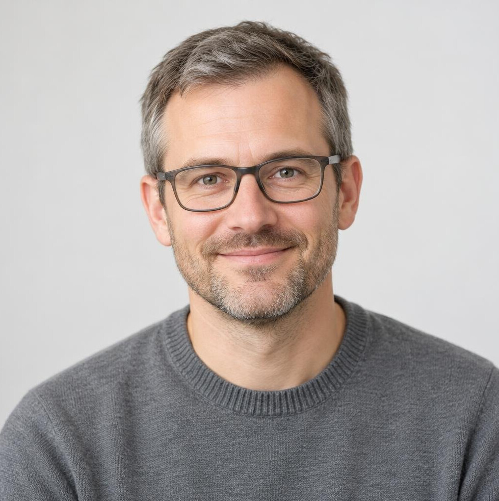 Portrait of a man with glasses and a grey sweater